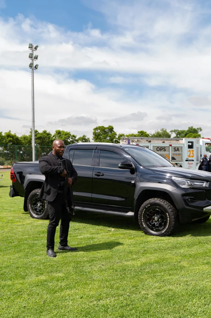 Hi Zone Security armed escort officer standing next to tactical vehicle protecting assets